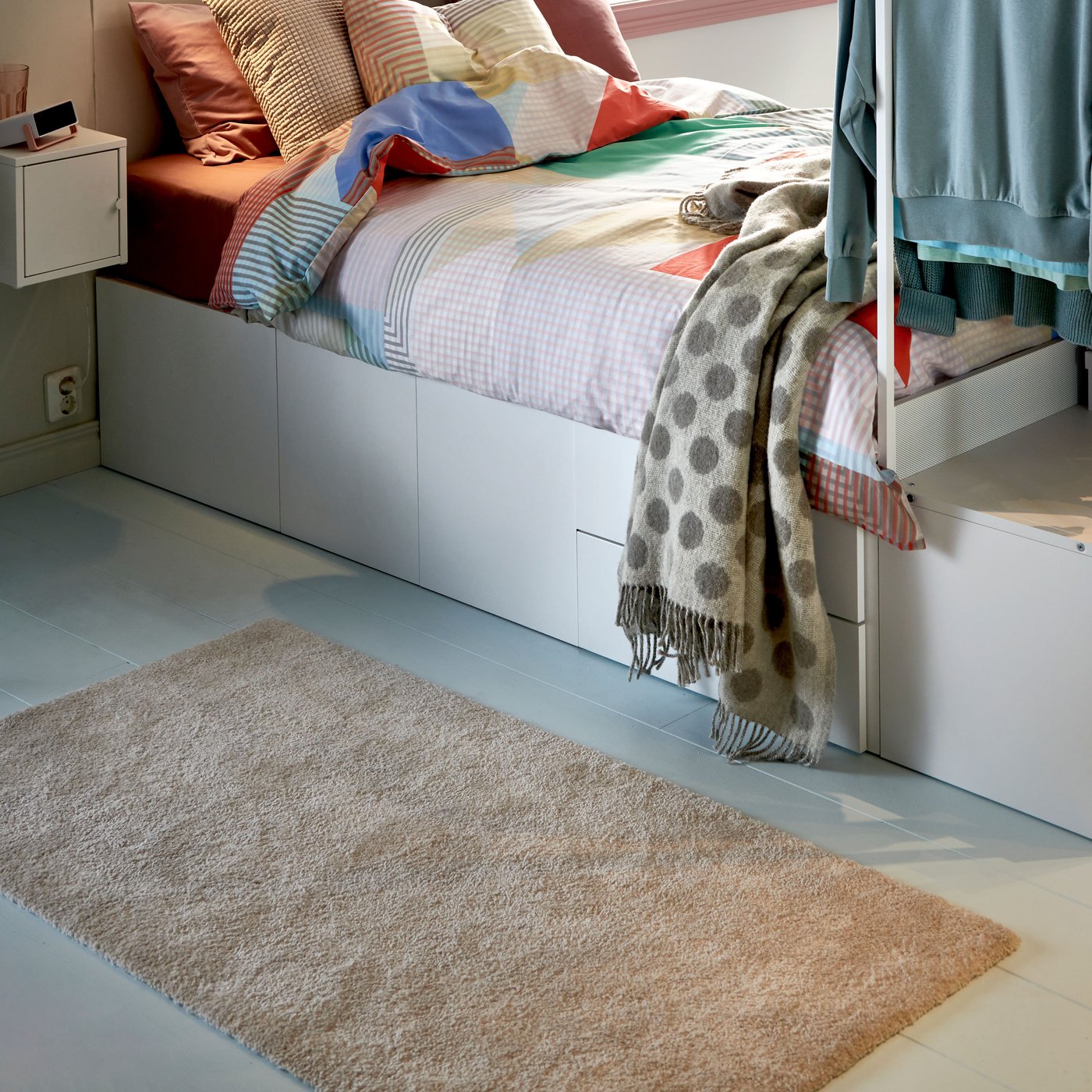 A beige RÅVAROR throw in the bedroom