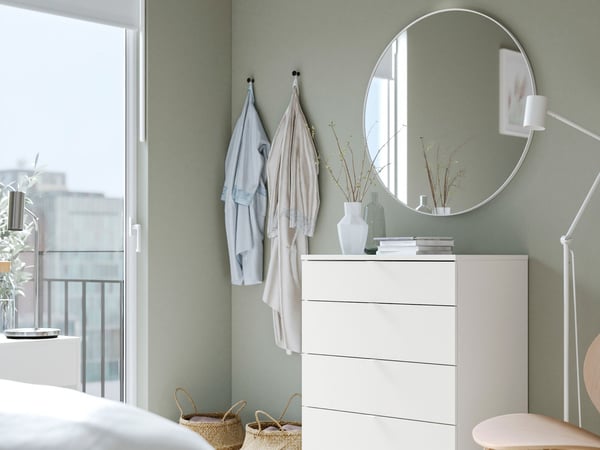 White VIHALS 4-drawer chest in bedroom setting with round mirror above.
