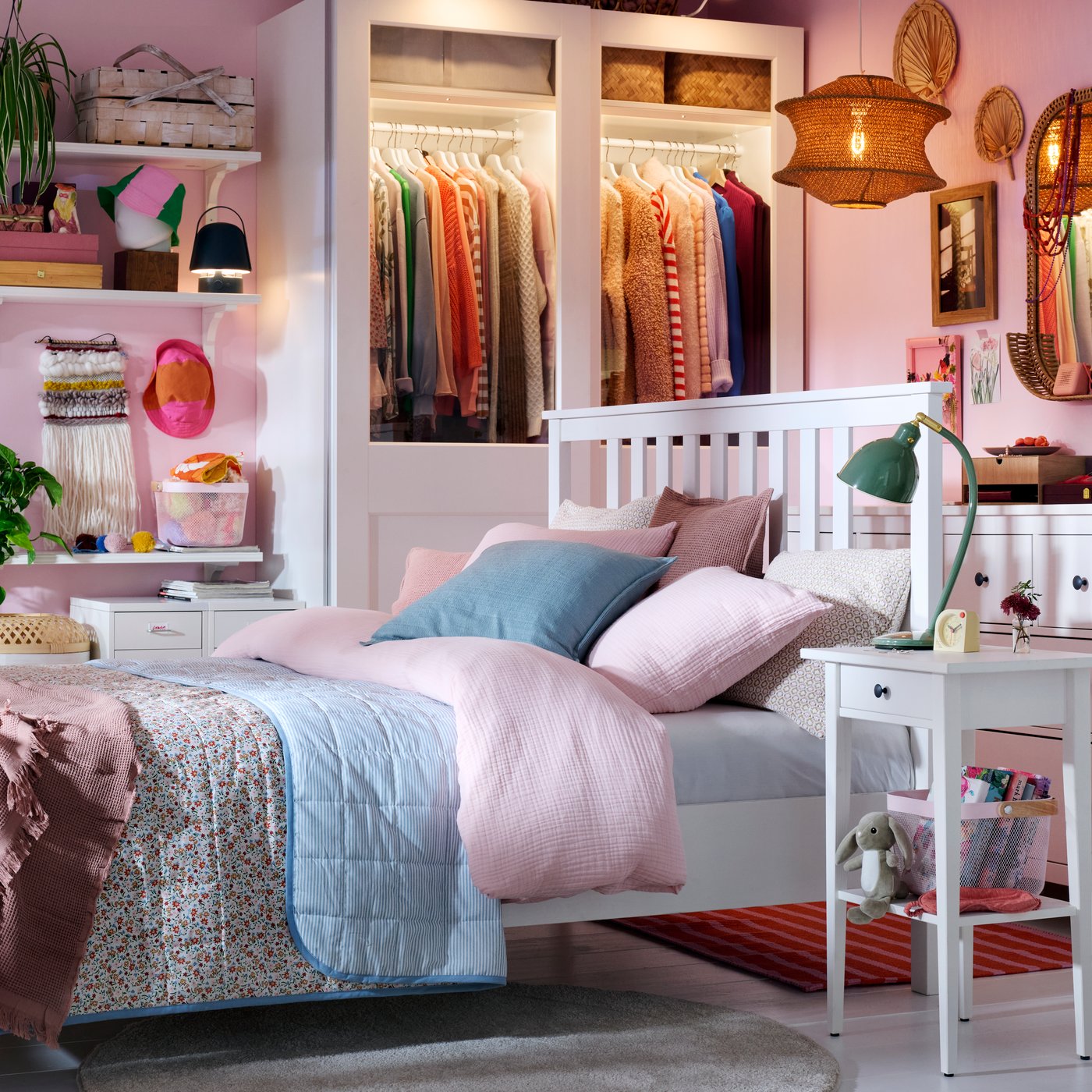 Una camera da letto dove dominano il rosa chiaro e il bianco con un letto HEMNES al centro e un guardaroba PAX/GRIMO sullo sfondo.