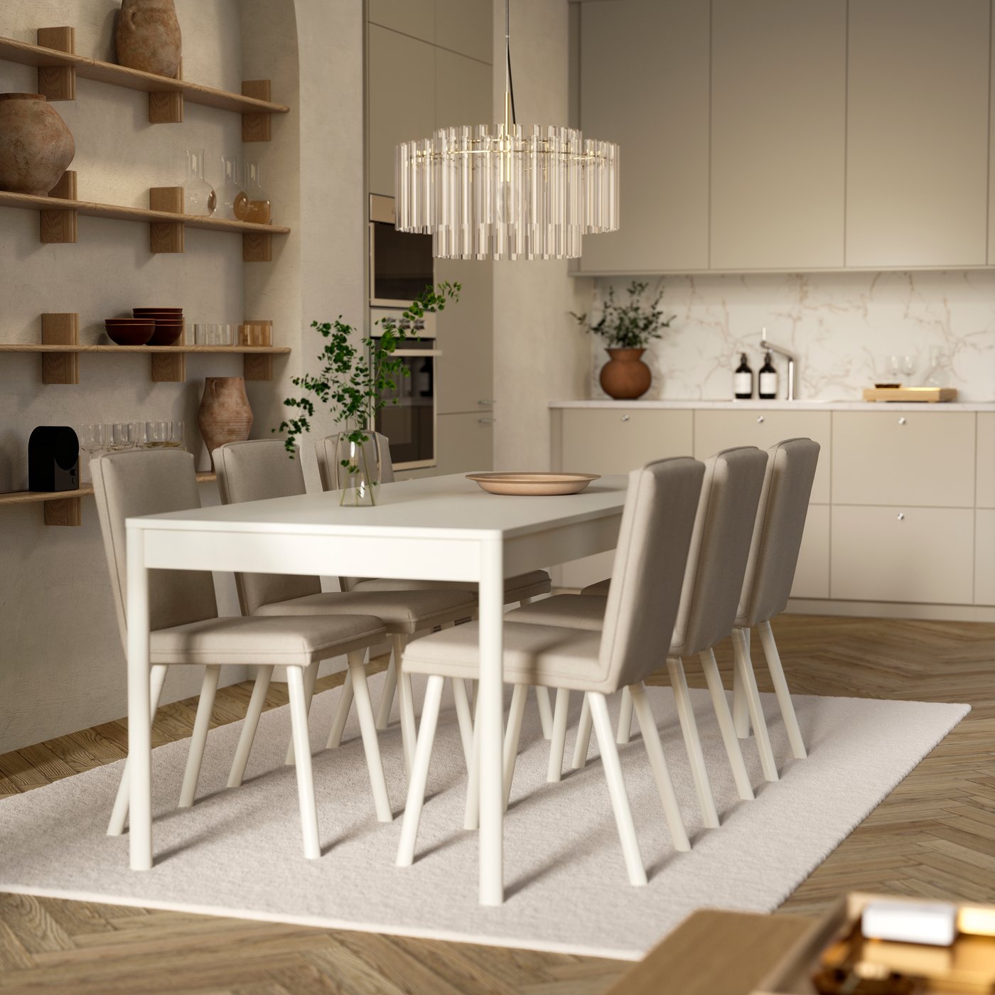 An off-white TONSTAD table with six chairs is on a rug and below a glass chandelier, by an open kitchen with modern fronts.