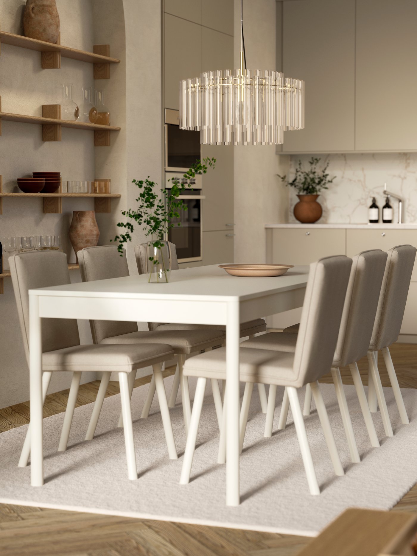 Une table TONSTAD blanc cassé avec six chaises est posée sur un tapis et sous un lustre en verre, à côté d'une cuisine ouverte aux façades modernes.