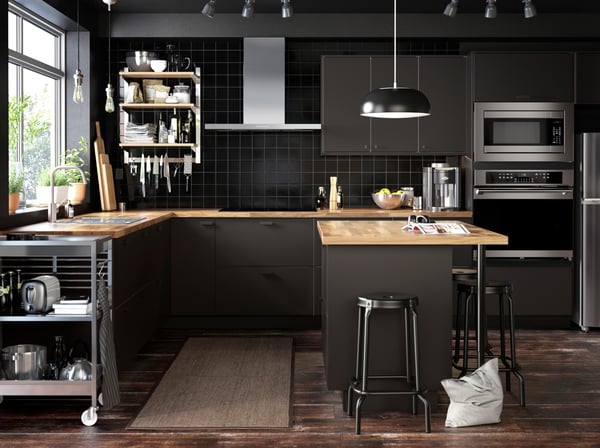 A dark kitchen with stainless steel appliances