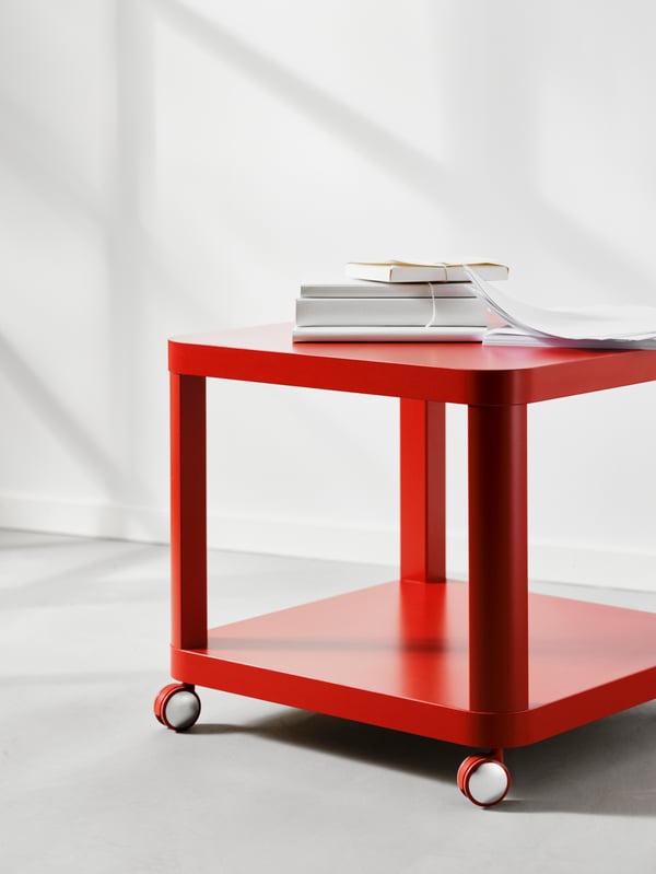 A red TINGBY side table on castors in the living room