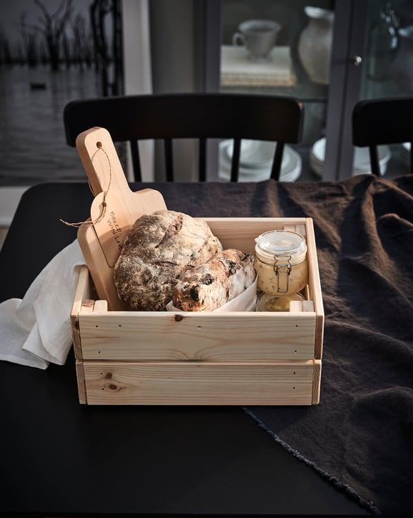 The IKEA KNAGGLIG breadbox is made of smooth and recyclable light pine wood and can be used as a food storage box after your friend finishes what’s inside.