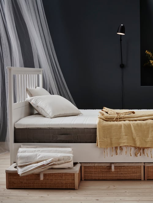 Schlafzimmer mit einem HEMNES Bettgestell mit einer HAMARVIK Federkernmatratze, einer TUDDAL Matratzenauflage, PUDERVIVA Bettwäsche und LILL Gardinenstore.