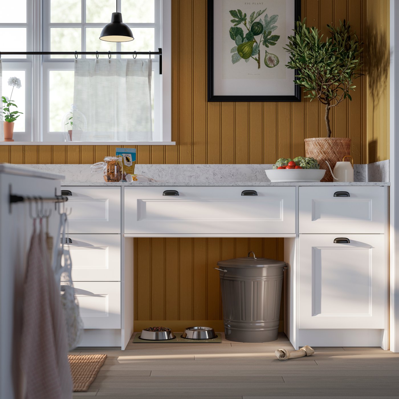 A bright kitchen featuring a sleek white kitchen island with drawers, surrounded by plants and kitchen accessories.