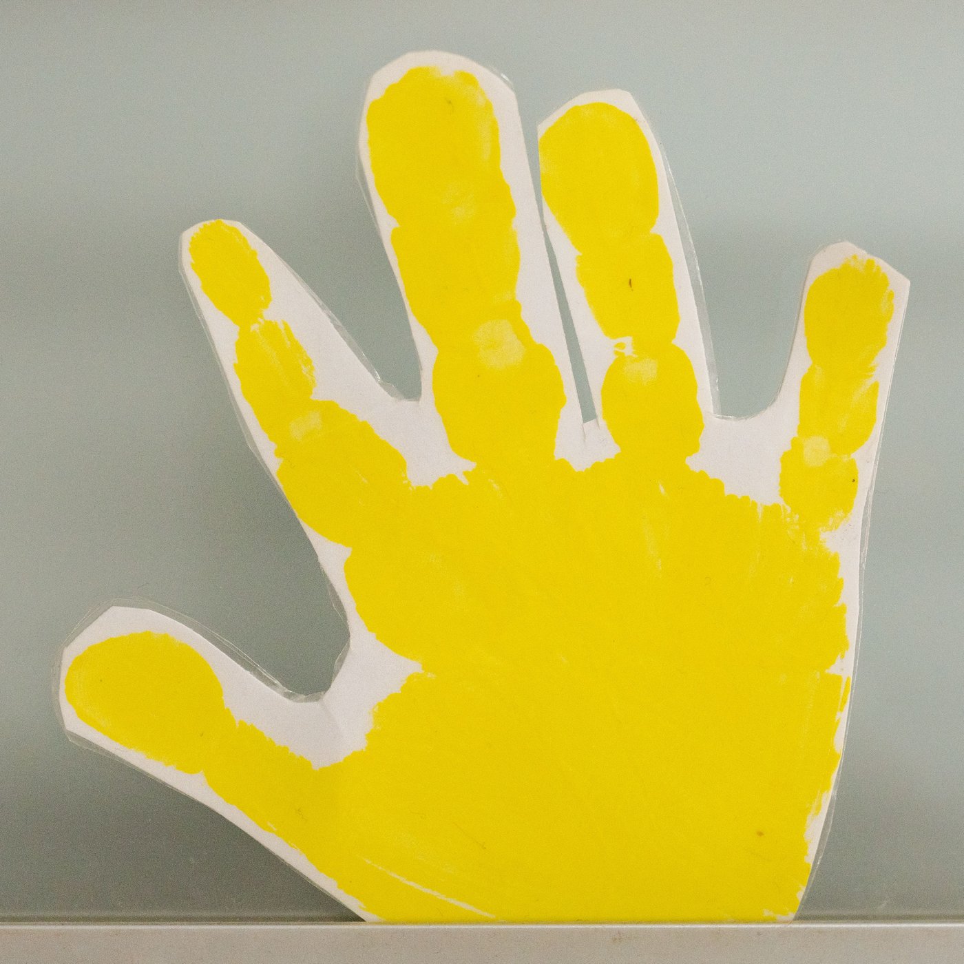 A yellow and white hand in paper is being photograped. 