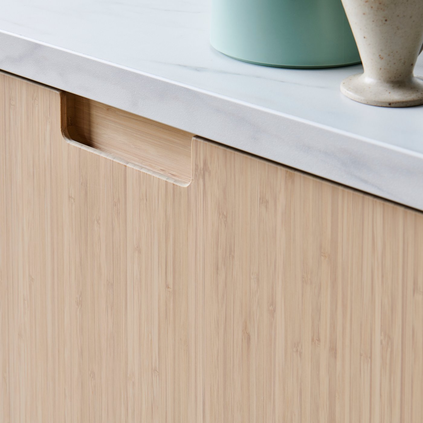 Bildausschnittt einer weiß marmorierte EKBACKEN Arbeitsplatte in Laminat in einer FRÖJERED Holzküche.