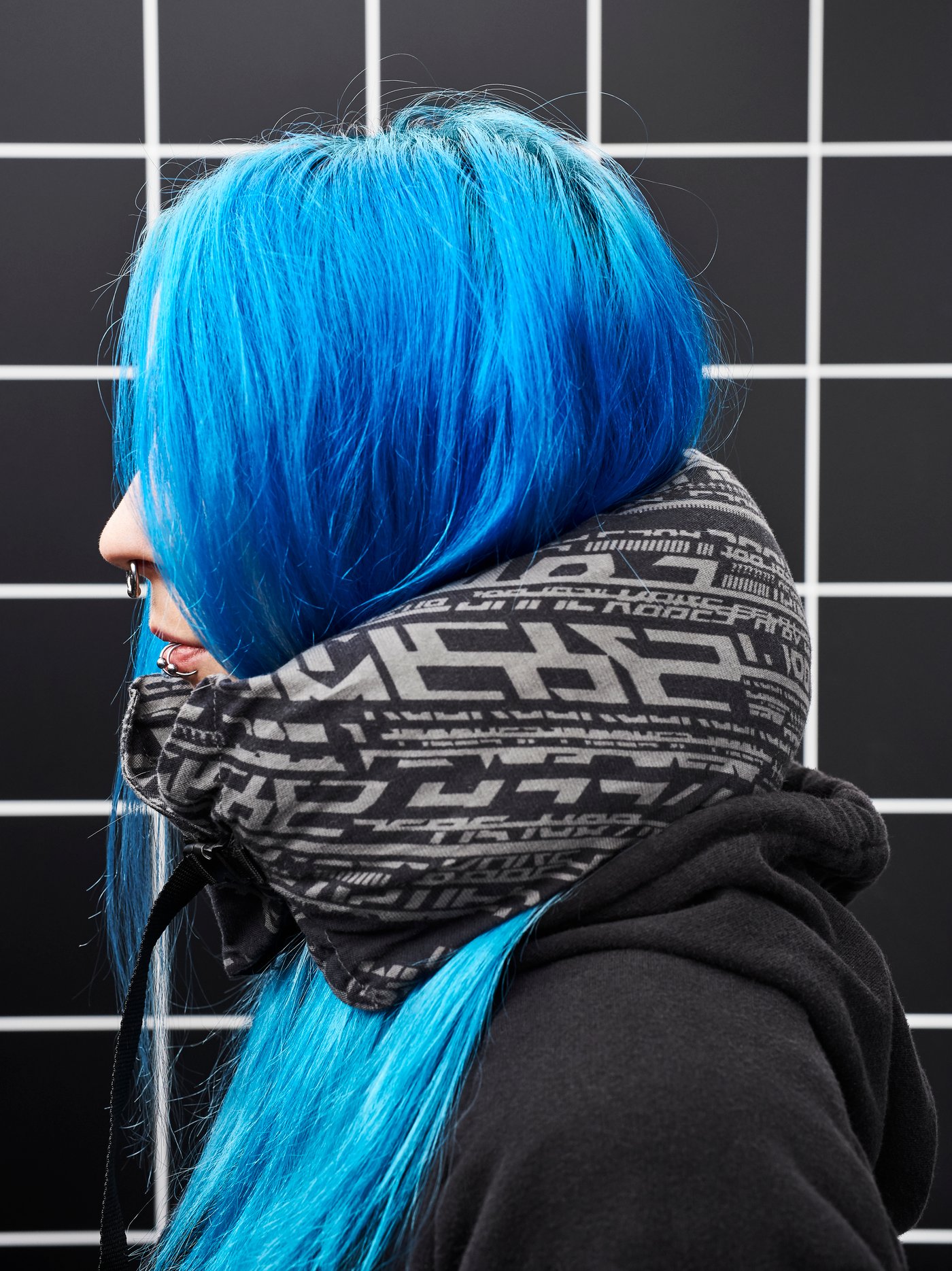 En tjej med blått hår har en LÅNESPELARE nackkudde runt nacken.