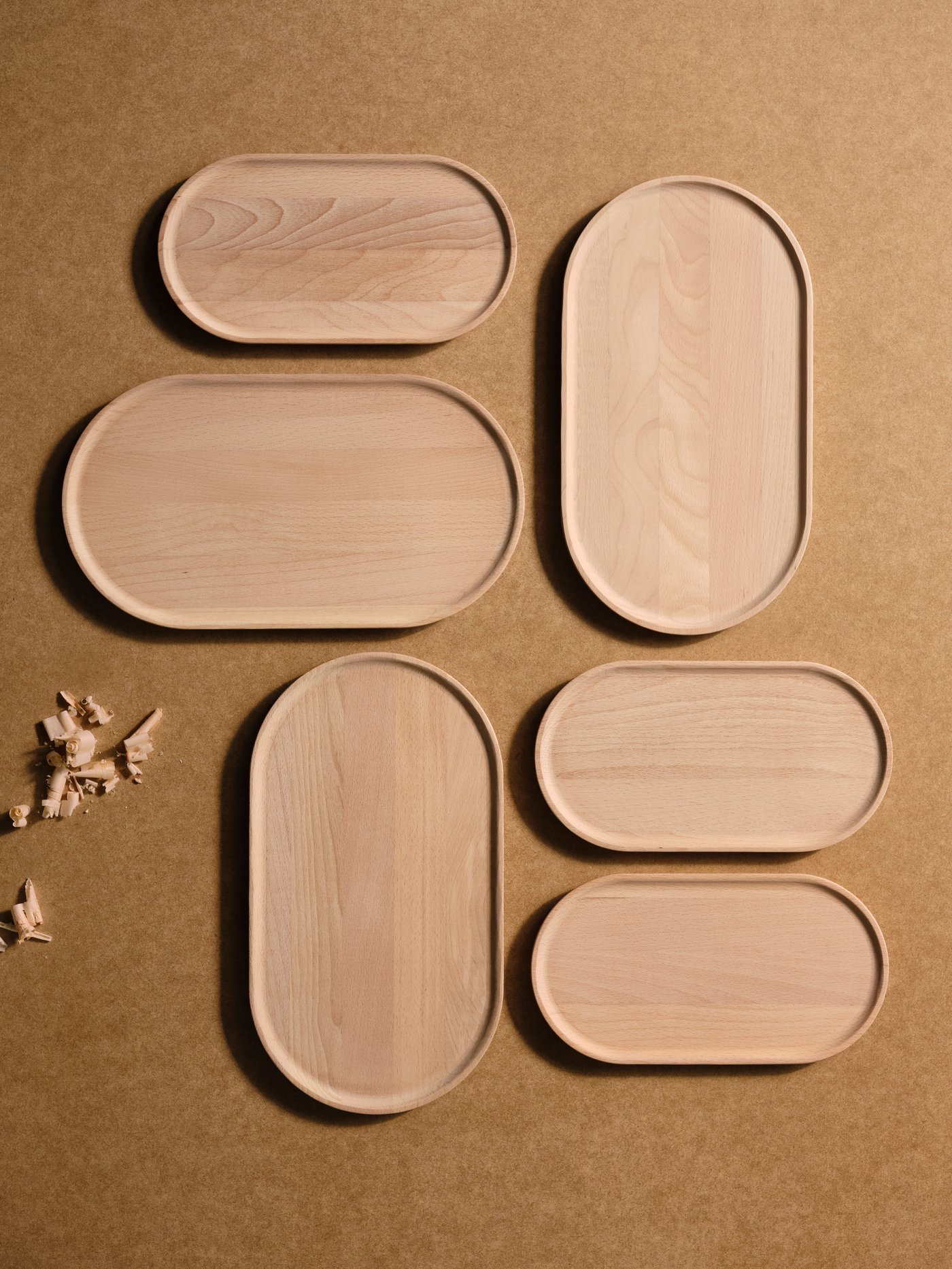 Aerial view of 6 SMÖRLING serving trays placed on a brown background.
