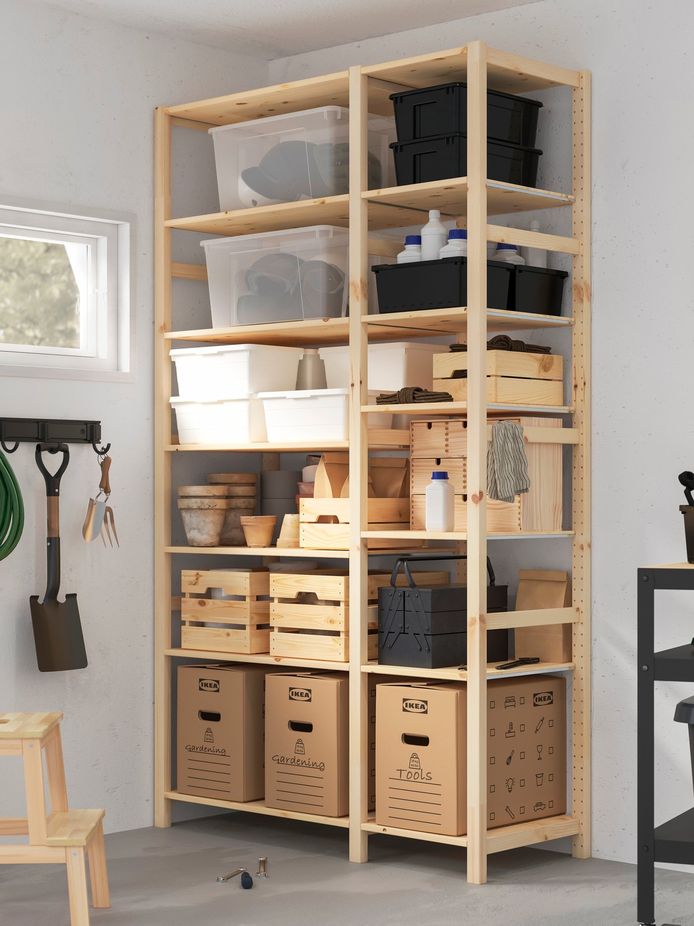 Uno scaffale in pino IVAR posto in un garage. Sui ripiani ci sono vari contenitori e scatole.