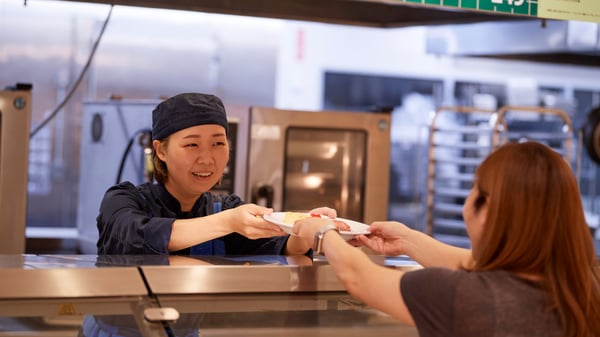 レストランでコワーカー（従業員）が料理をサービングしている。