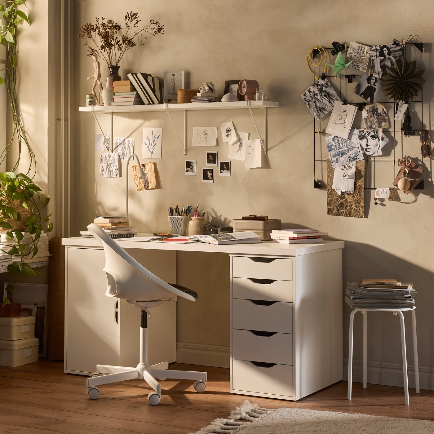 Una scrivania ALEX bianca, con cassetti e un mobile con anta come sostegno. Una sedia con rotelle girevoli bianca.