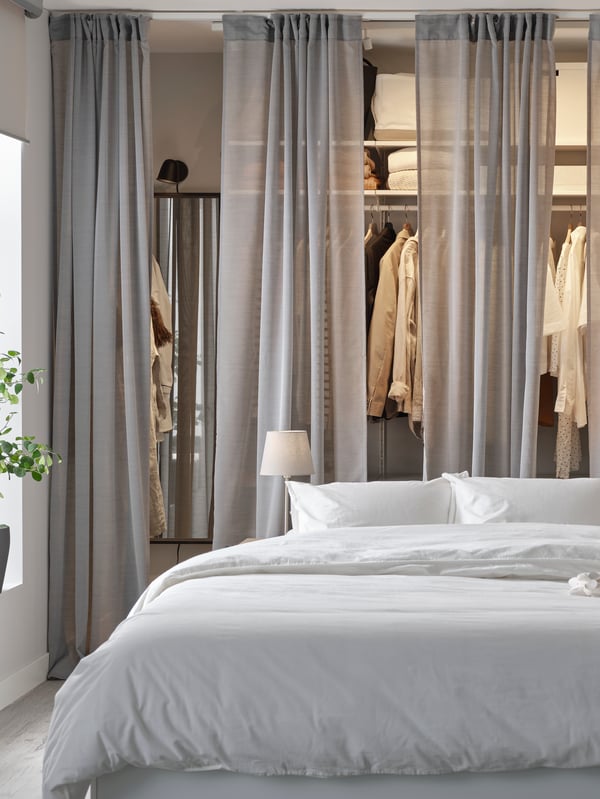 Imagen de una cama con armarios al fondo iluminada por una luz.