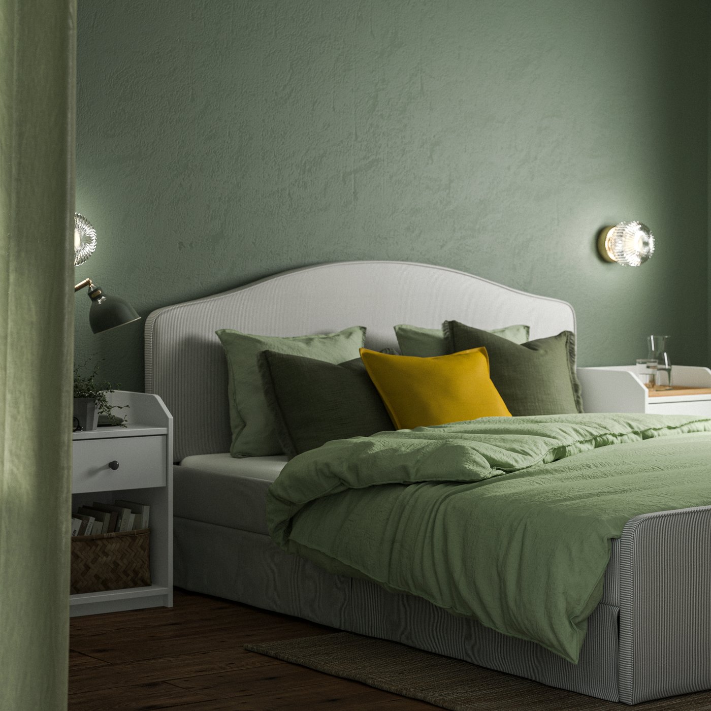 Ett sovrum med mjukt gröna väggar och en RAMNEFJÄLL stoppad säng med gröna sängkläder och många kuddar.