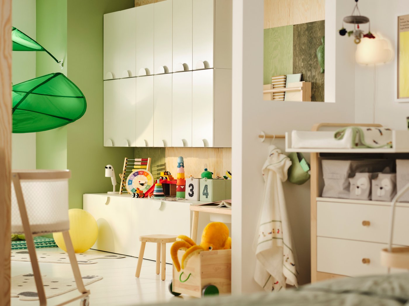 Una habitació infantil parcialment separada per una paret. Hi ha armaris SMÅSTAD i joguines a un costat. A l'altre, hi ha una zona amb un canviador.
