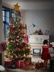Young girl puts handmade decoration on Christmas tree. Camera pulls back to reveal tree filled with VINTERFINT tree ornaments 