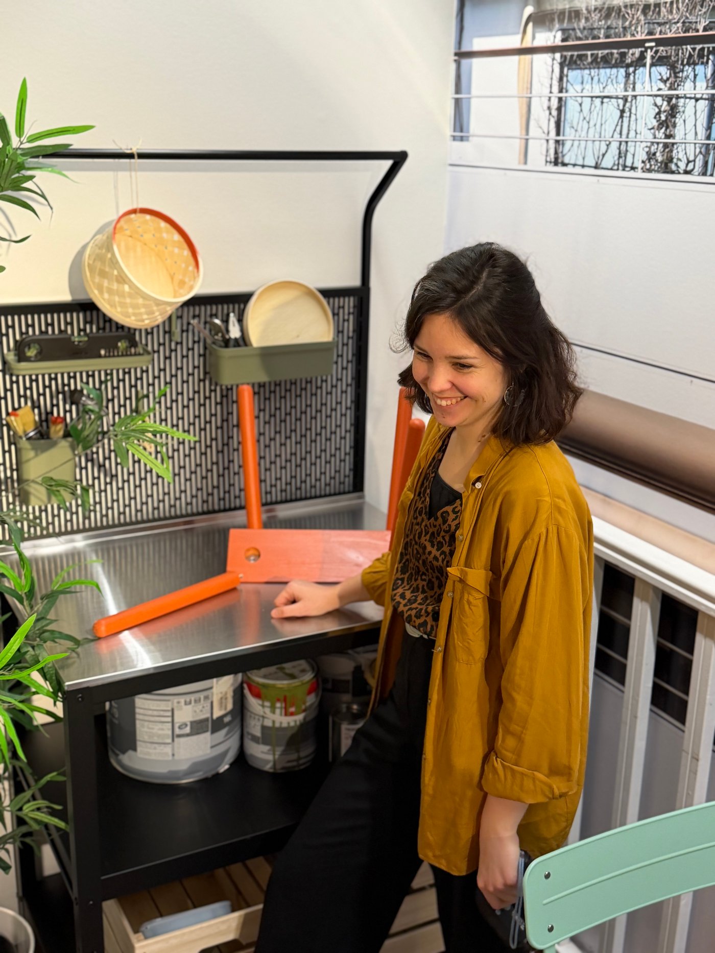Une femme souriante sur son balcon près de son atelier créatif