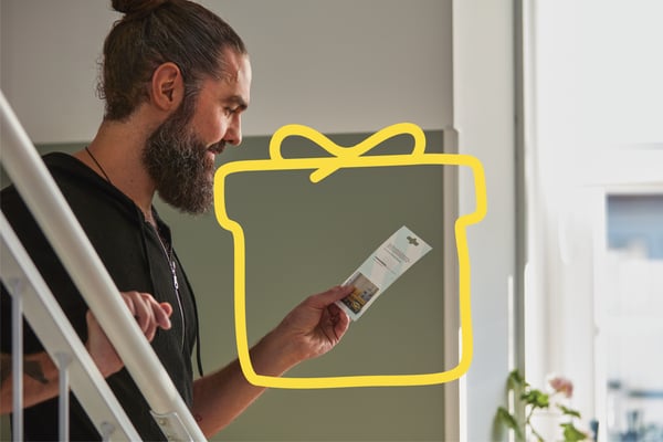 Man holding IKEA gift card smiling.