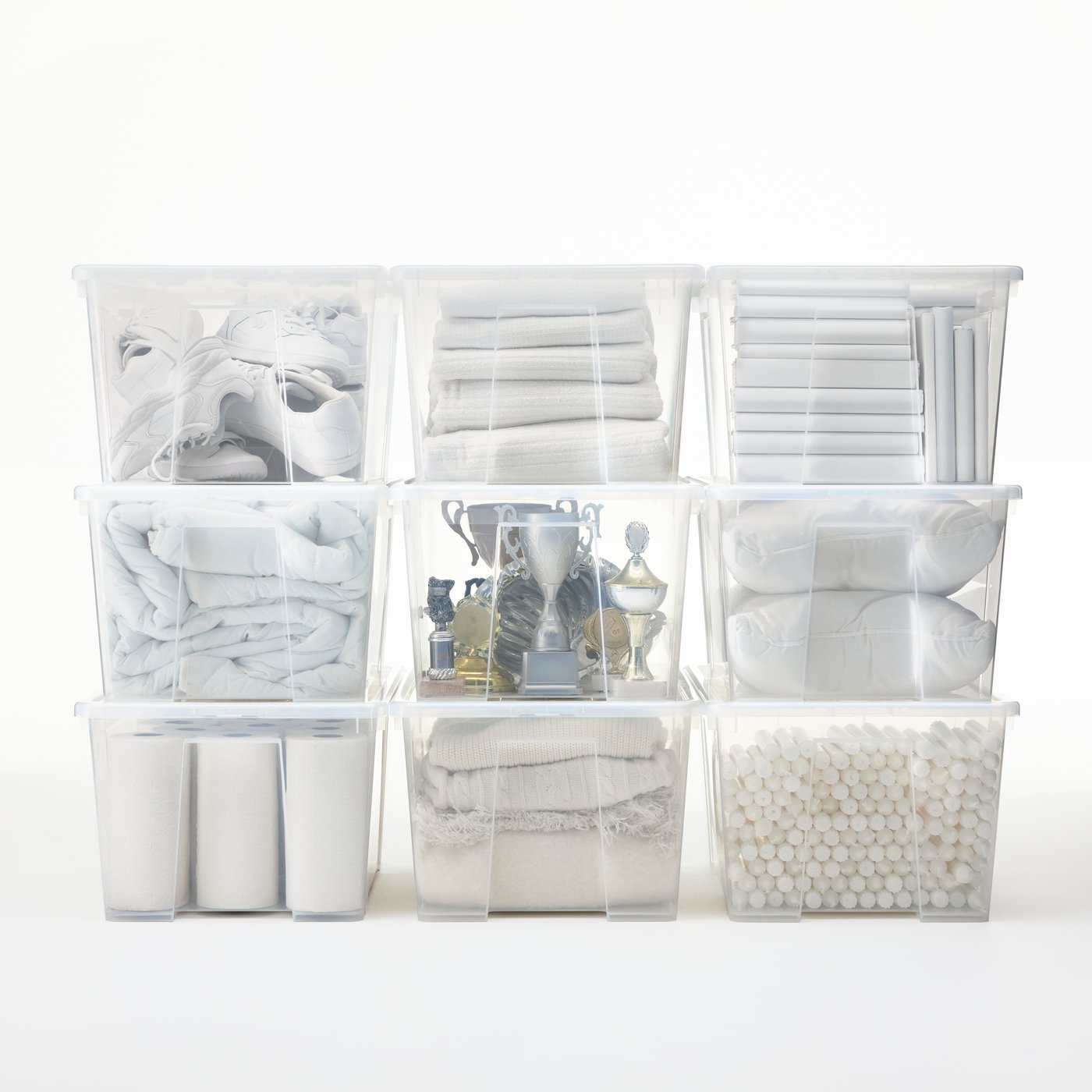 A storage area with transparent SAMLA boxes neatly stacked in rows. In the middle, a box with old sport trophies.
