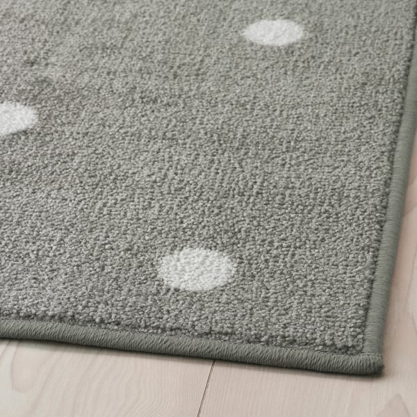 Ein grauer LEN Teppich kurzflor, mit weißen Punkten.