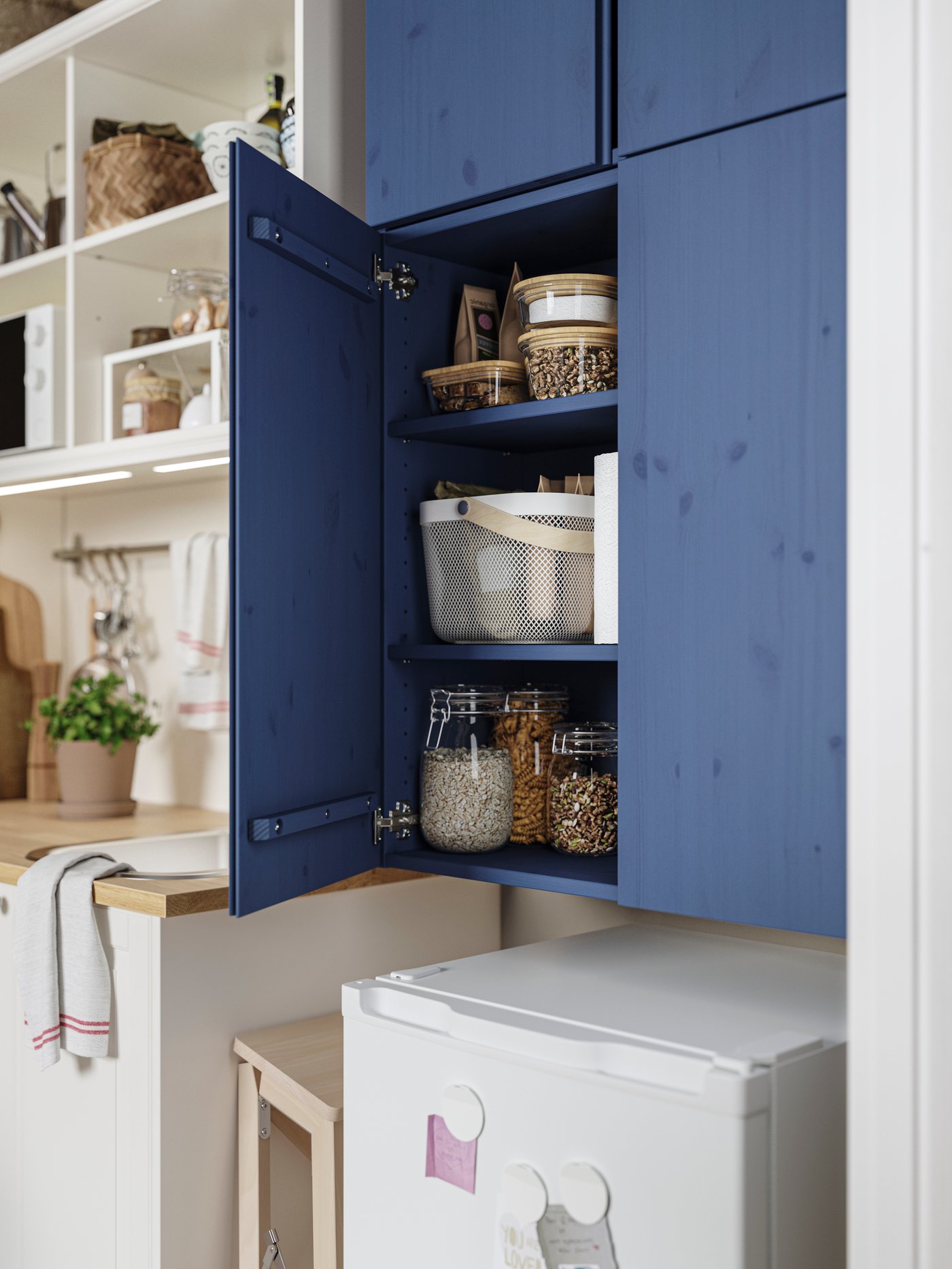 Es ist eine Nahaufnahme von vier IVAR Schränken in Blau neben einer weißen ÖNNERUP Kochnische  und einem ebenfalls weißen LAGAN Kühlschrank zu sehen.