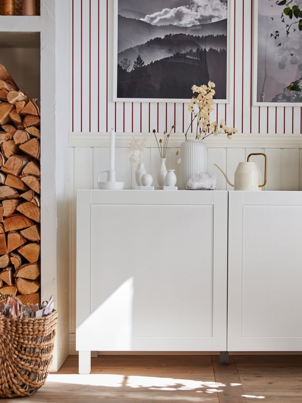 BESTÅ storage unit with white SMEVIKEN doors. On top of the cabinet are some decorations.