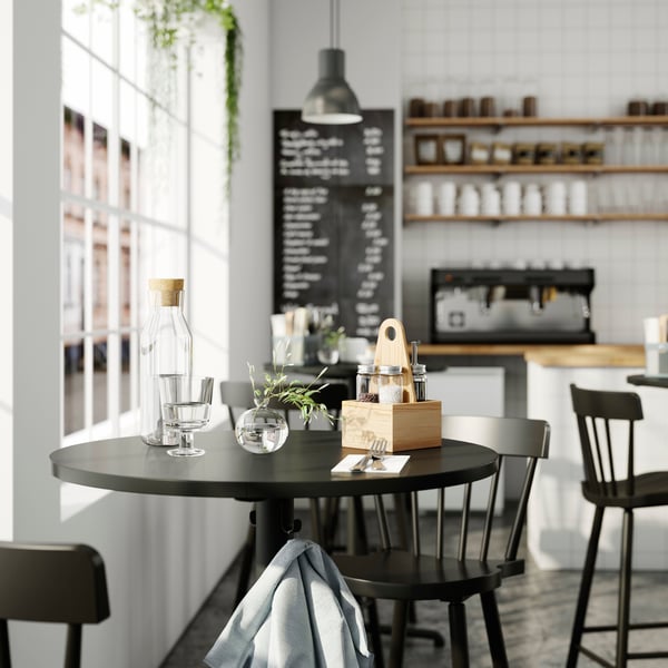 Tavolo apparecchiato con portaoggetti portatile CHOKLADHAJ e bicchiere e brocca d'acqua IKEA 365+.