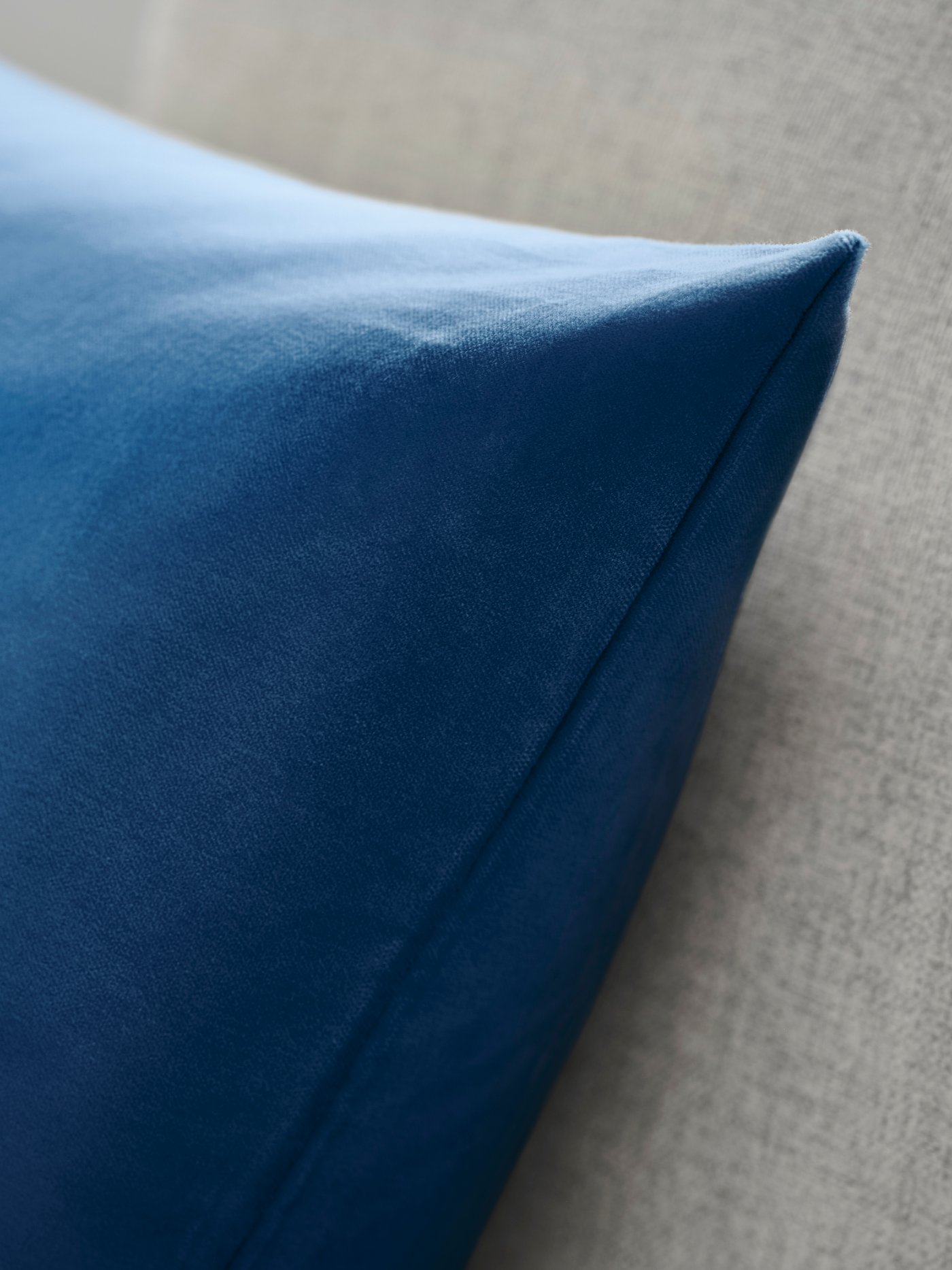 A blue SANELA cushion cover