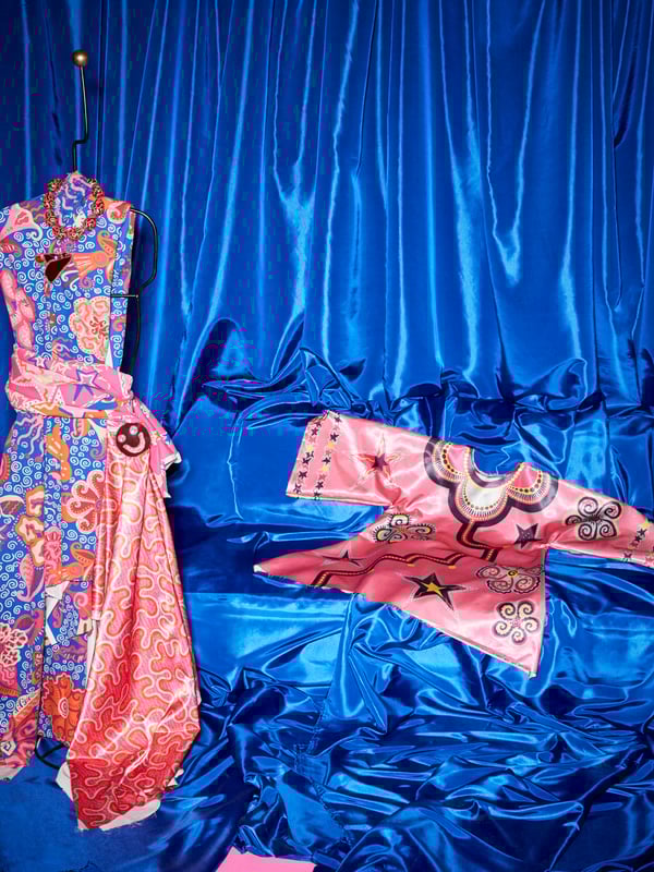 Eine KARISMATISK Stoffbahn in Rosa ist zu einem Kleid genäht und schmückt eine Schneiderpuppe; im Hintergrund liegt ein selbst genähter Kaftan aus KARISMATISK Stoffbahnen in Rosa.