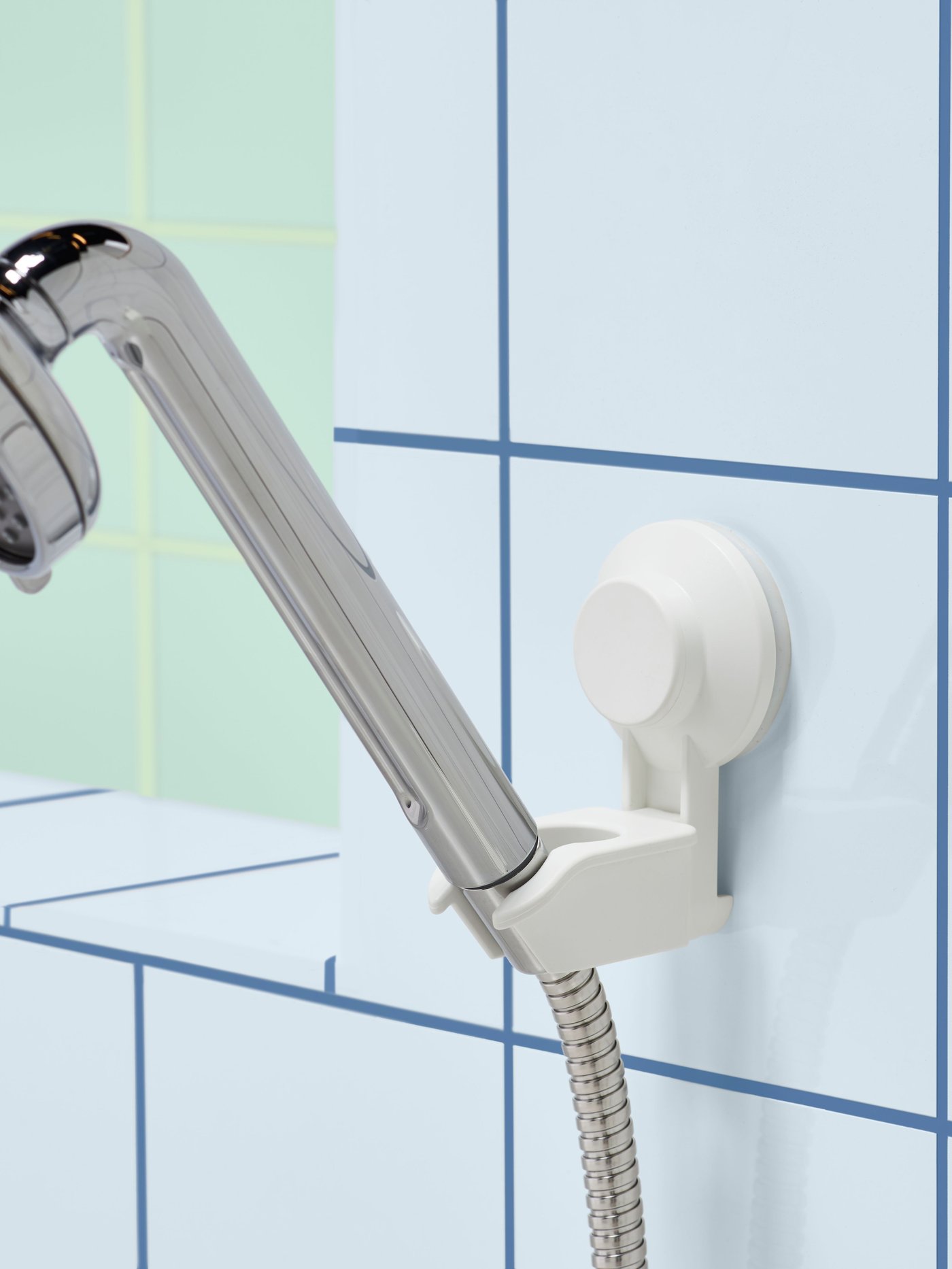 Um suporte de chuveiro de mão TISKEN branco com ventosa na casa de banho.