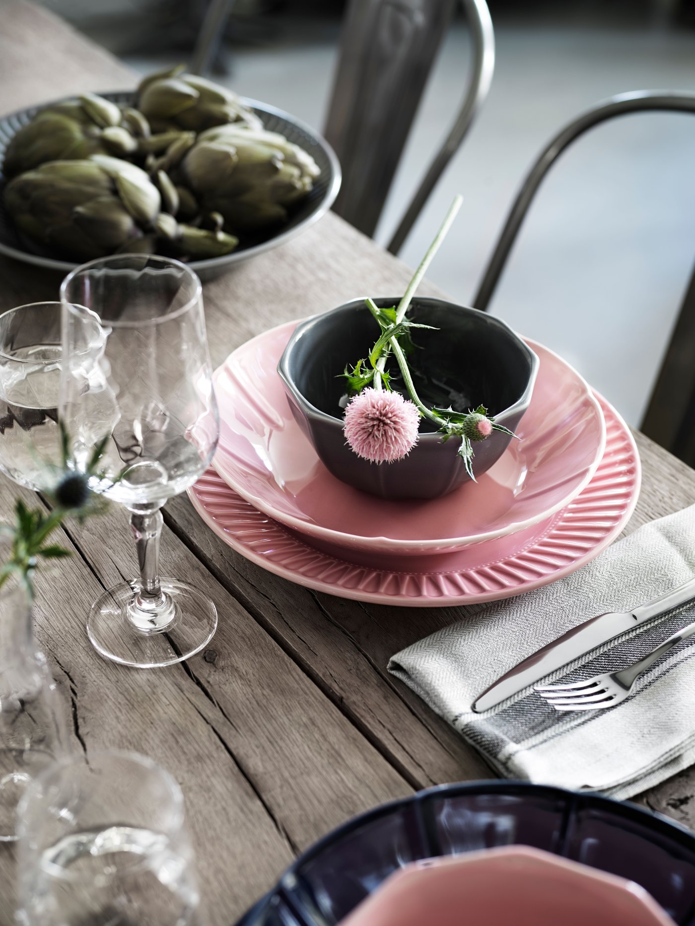 A table setting with STRIMMIG flower-inspired tableware in green. There is also a white plate with two eggs on the table.