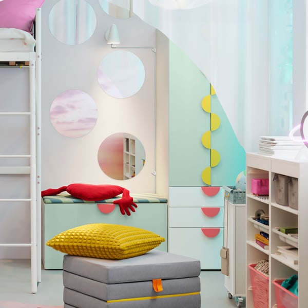 A VITVAL loft bed with desk top stands beside a SMÅSTAD/PLATSA storage combination with bench in a child’s room.