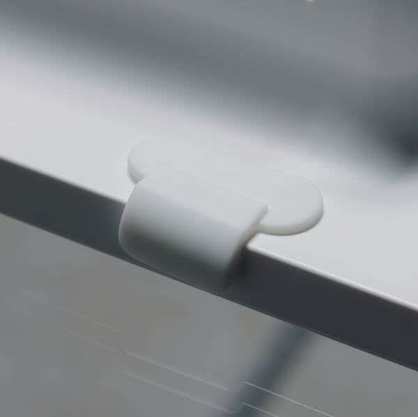 Velmi detailní záběr magnetického háčku na zadní straně bílého rámu na obrazy SYMFONISK s reproduktorem WiFi.