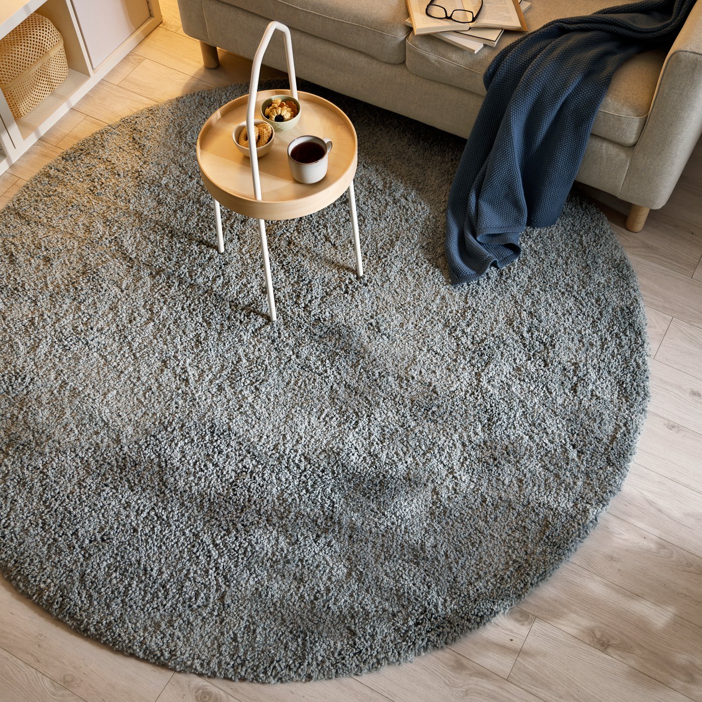 Vaaleanharmaa, korkeapintainen STOENSE‑matto kuvattuna ylhäältä olohuoneessa.”