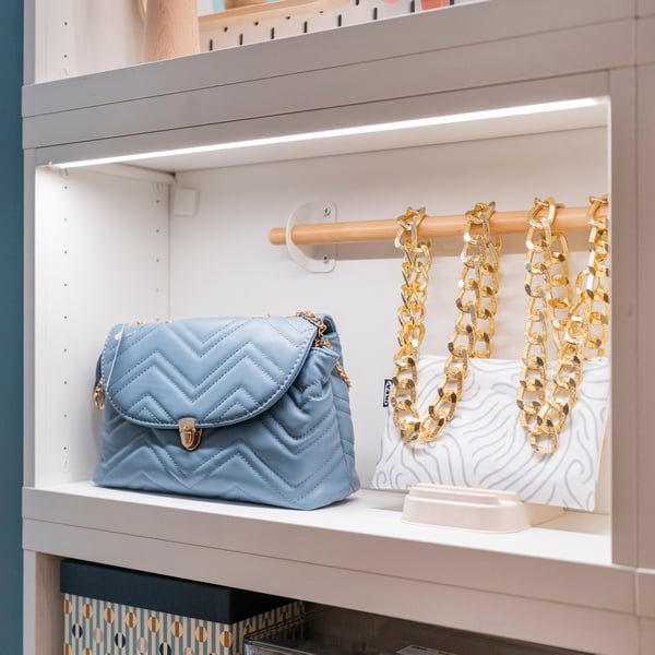 A backlit built in shelving unit holds different accessories.