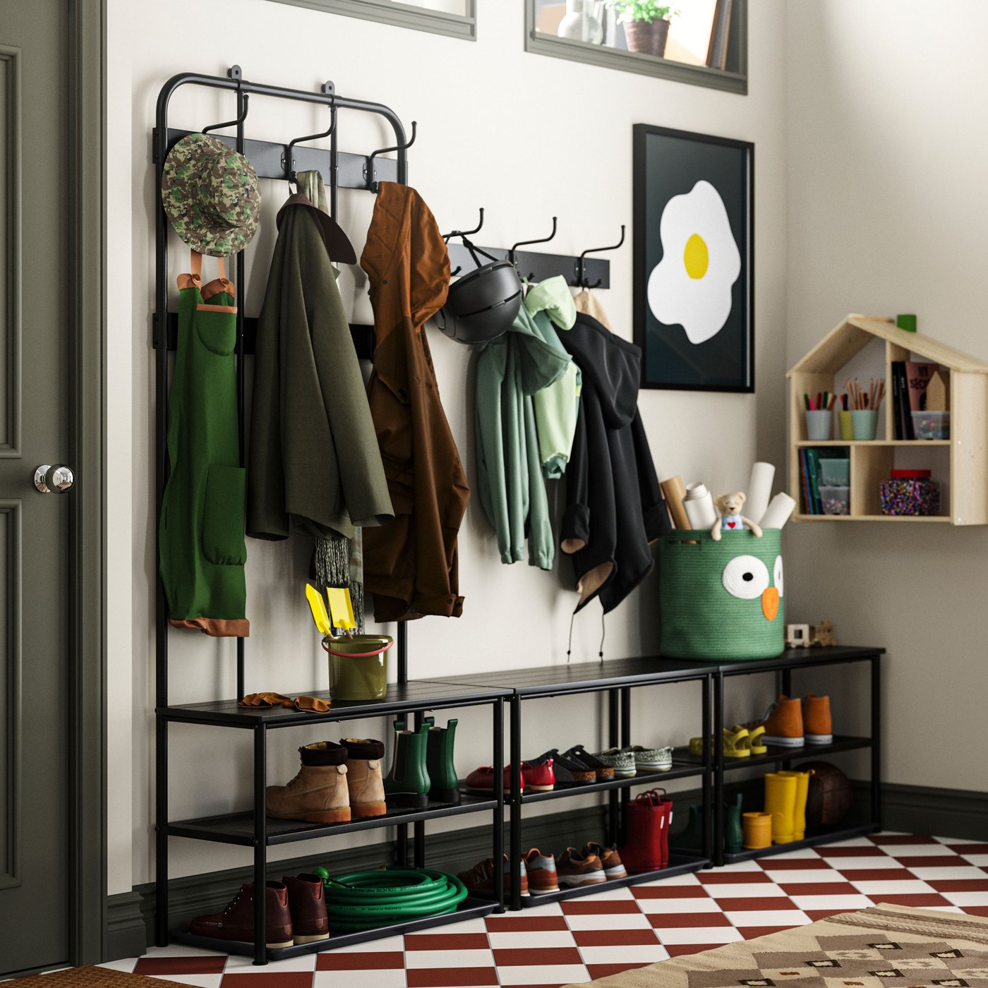 En stor hall med trappa som leder upp till ett kök. NIPÅSEN klädhängare och bänkar samt en arbetsbänk längs väggarna.