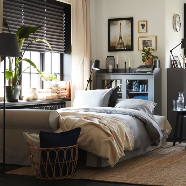 A natural LOHALS rug, flatwoven in the bedroom