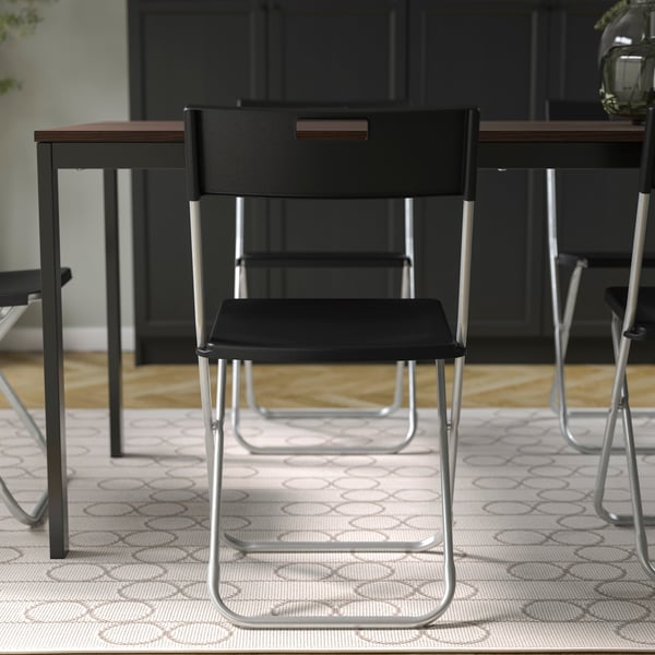 A black GUNDE folding chair