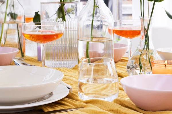 Gros plan sur des verres à eau et des coupes à champagne sur une table dressée