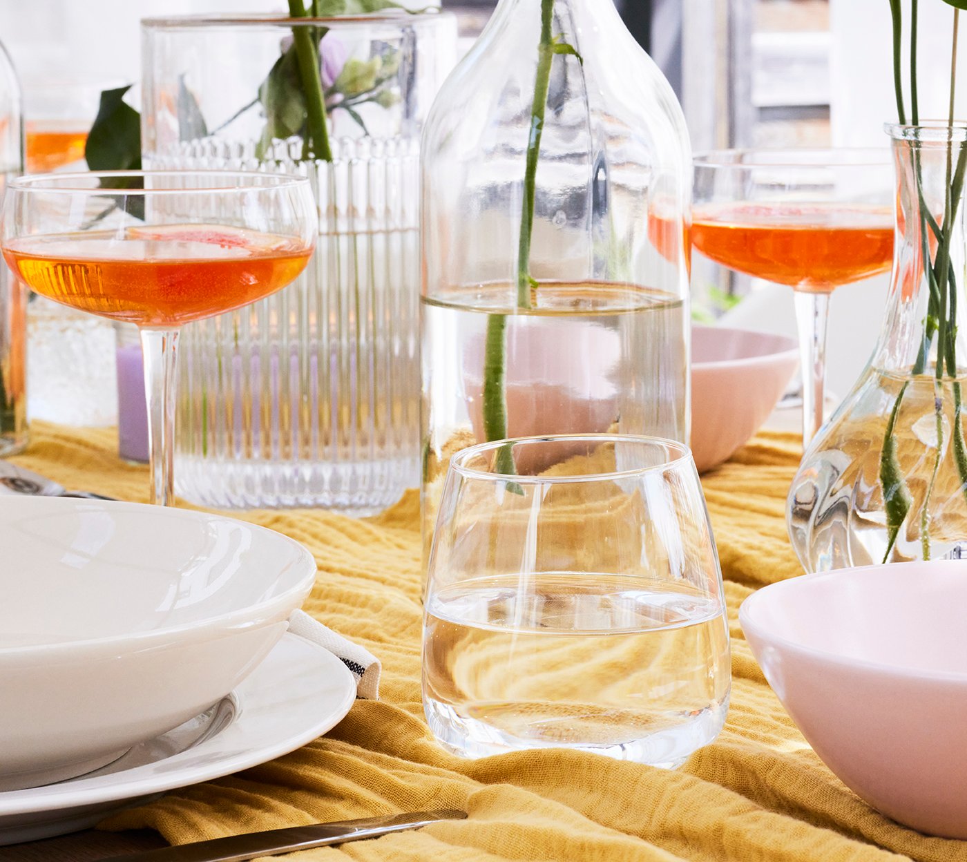 Nahaufnahme von Wassergläsern und Sektschalen auf einem gedeckten Tisch