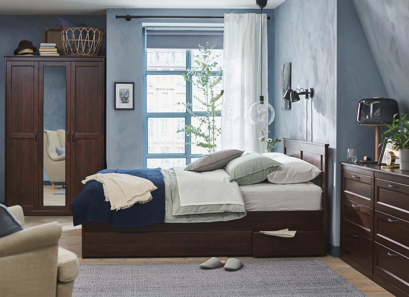 A brown SONGESAND bed frame with 4 storage boxes in the bedroom