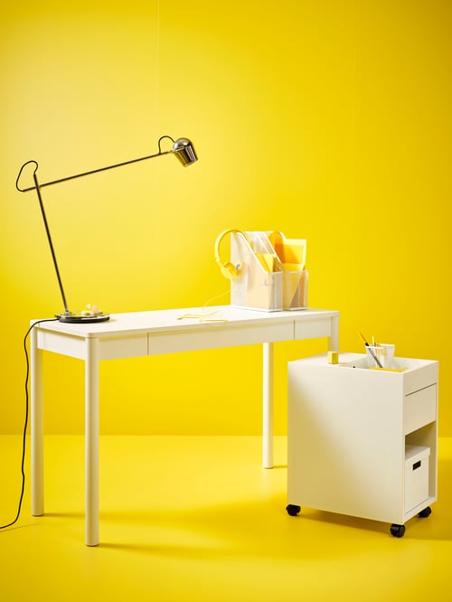 Workspace corner featuring a white TONSTAD desk placed next to a white TONSTAD drawer unit on castors.