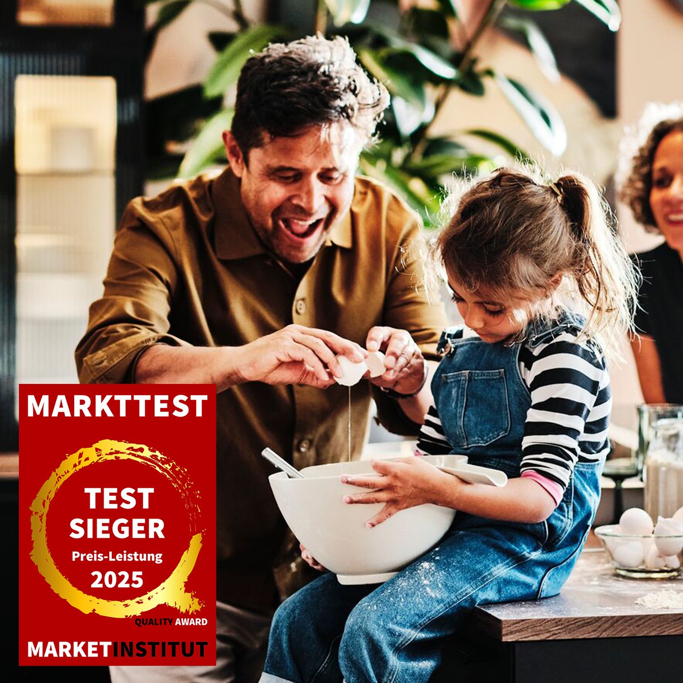 You see a man baking with a child. In the foreground, the Market Test logo is visible, indicating “Test sieger - Preis Leistung 2025".
