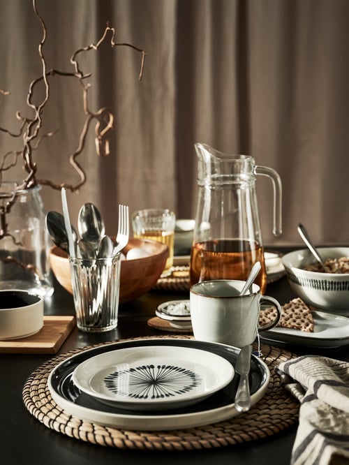 Close-up of table setting with white and grey dinnerware and classy mug with grey coloured glaze and clean shapes.