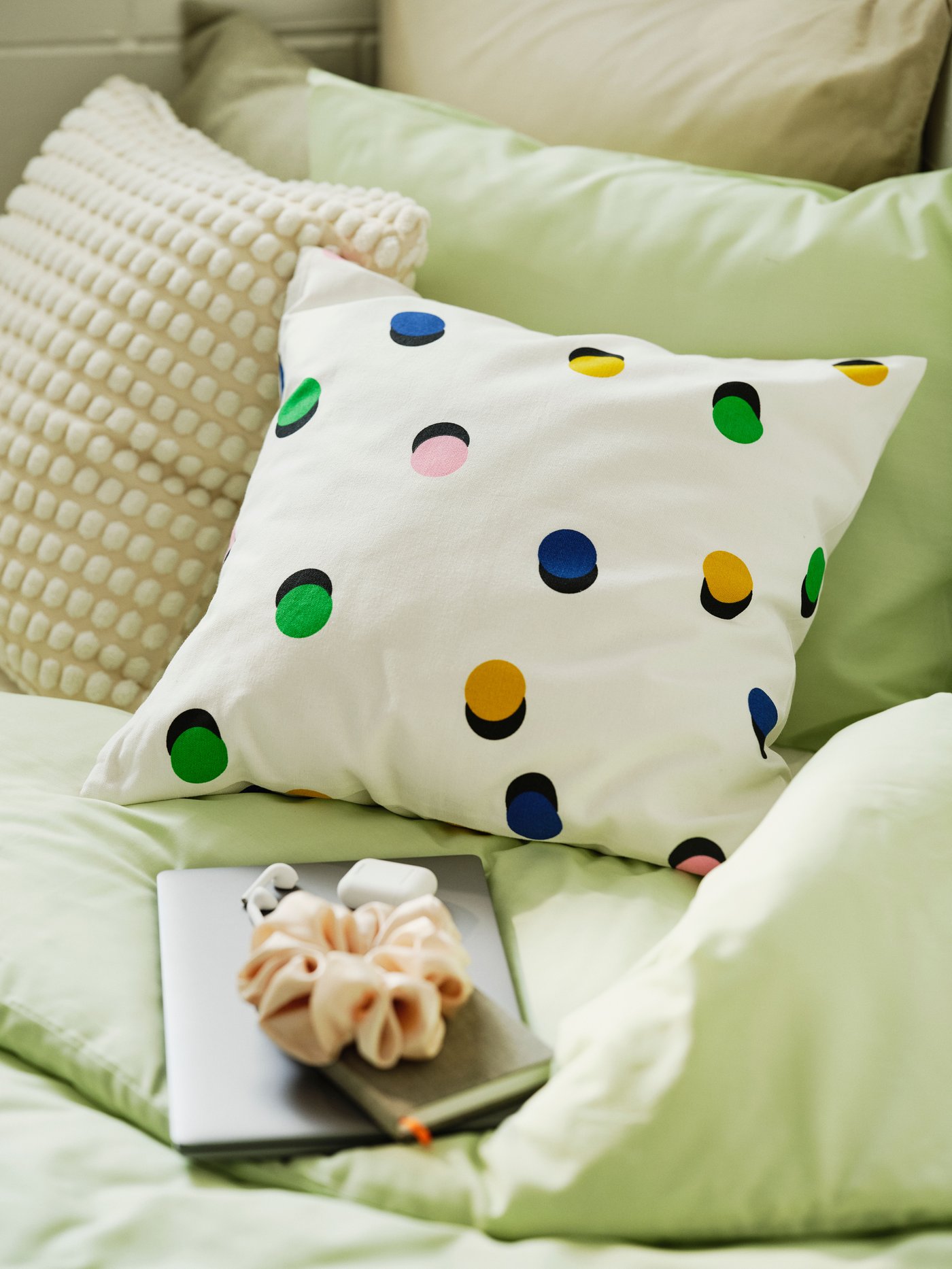 Colorful pillow on a green duvet