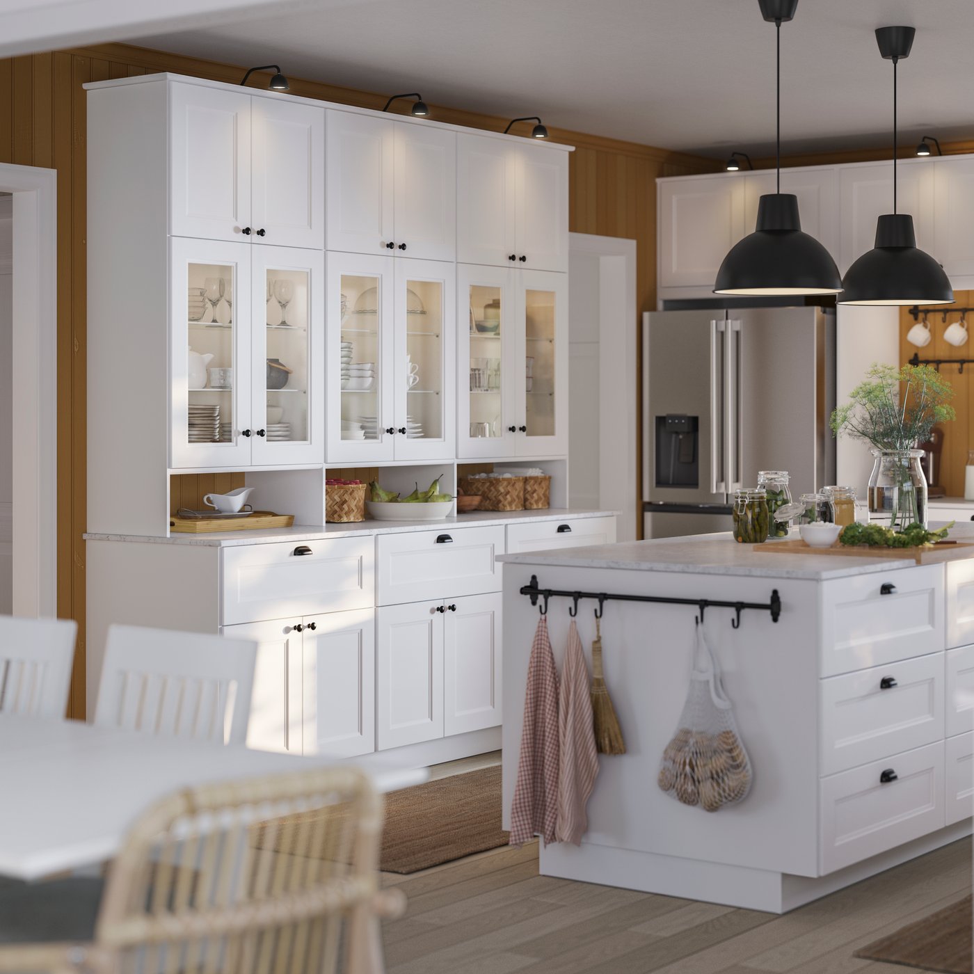 A white AXSTAD kitchen featuring a large island, glass-front cabinets, and stainless steel appliances, and pendant lights.