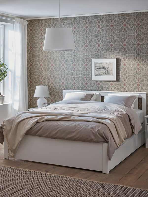 A white SONGESAND bed frame with 2 storage boxes