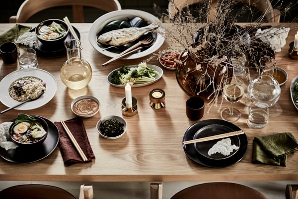 Une table à manger en acacia/noir SKOGSTA dans la salle à manger