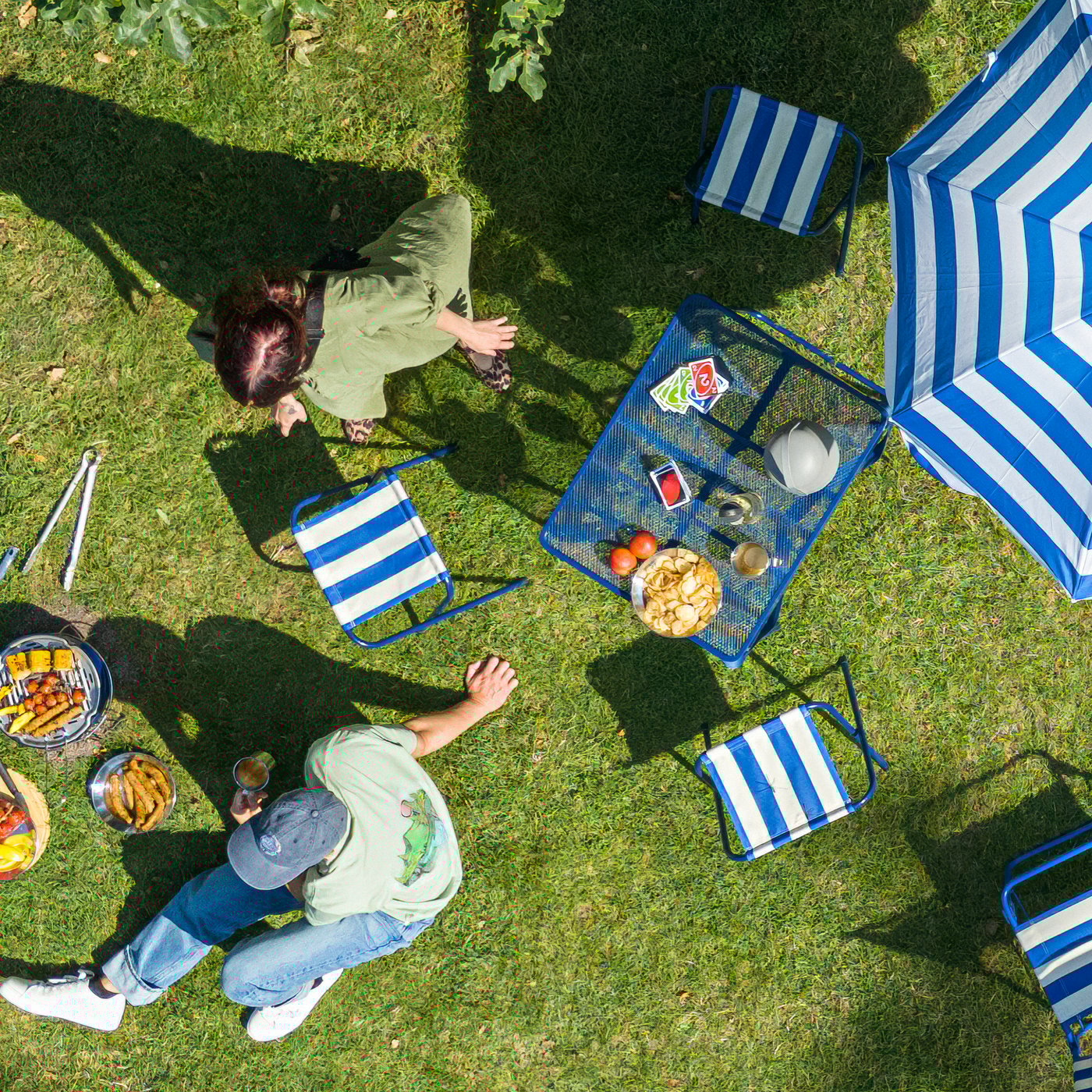 KALLSINNIG and PILLESTARR blue glasses on an outdoor table, along with an IKEA 365+ jar filled with lemonade.